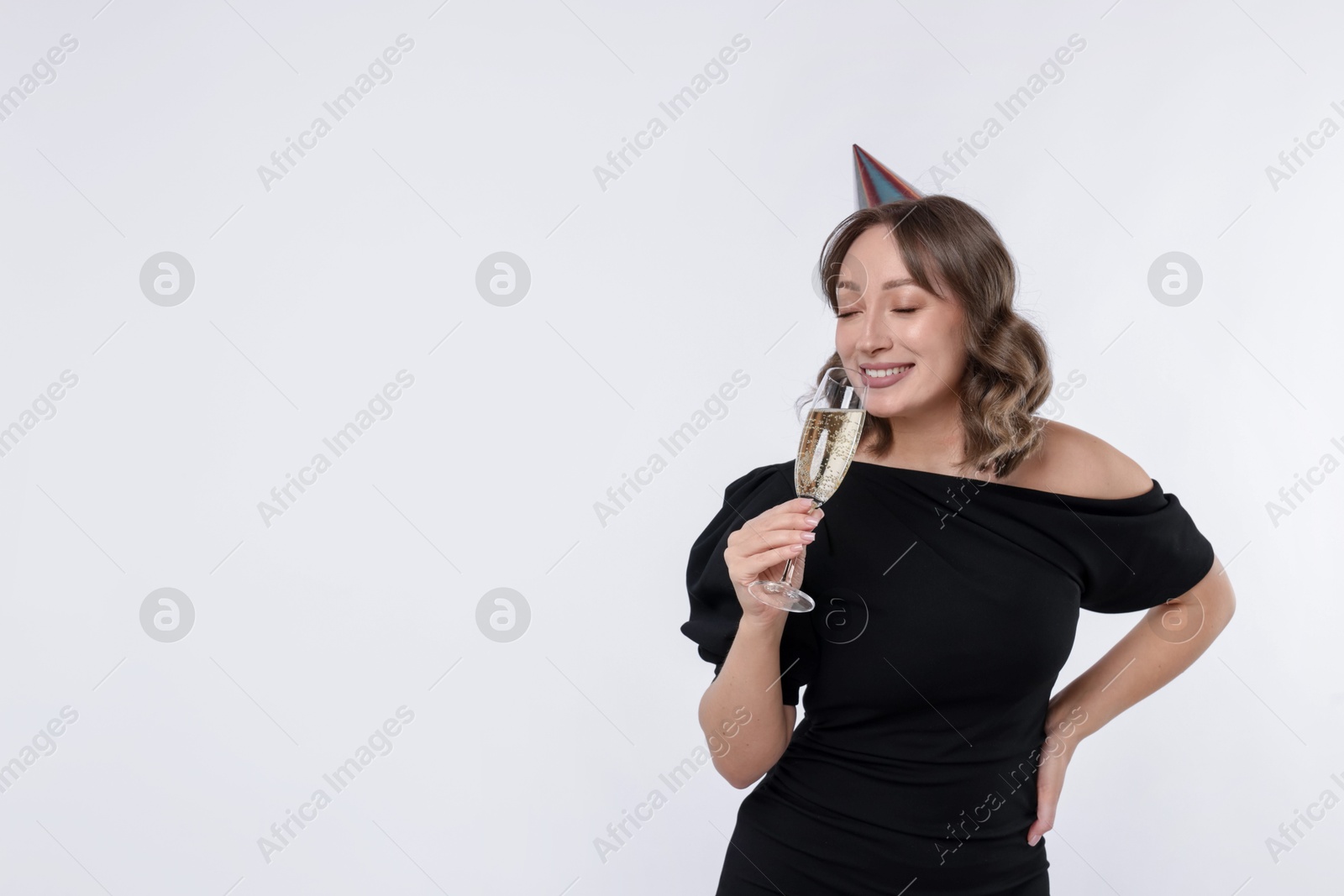 Photo of Birthday celebration. Woman with glass of sparkling wine on white background. Space for text