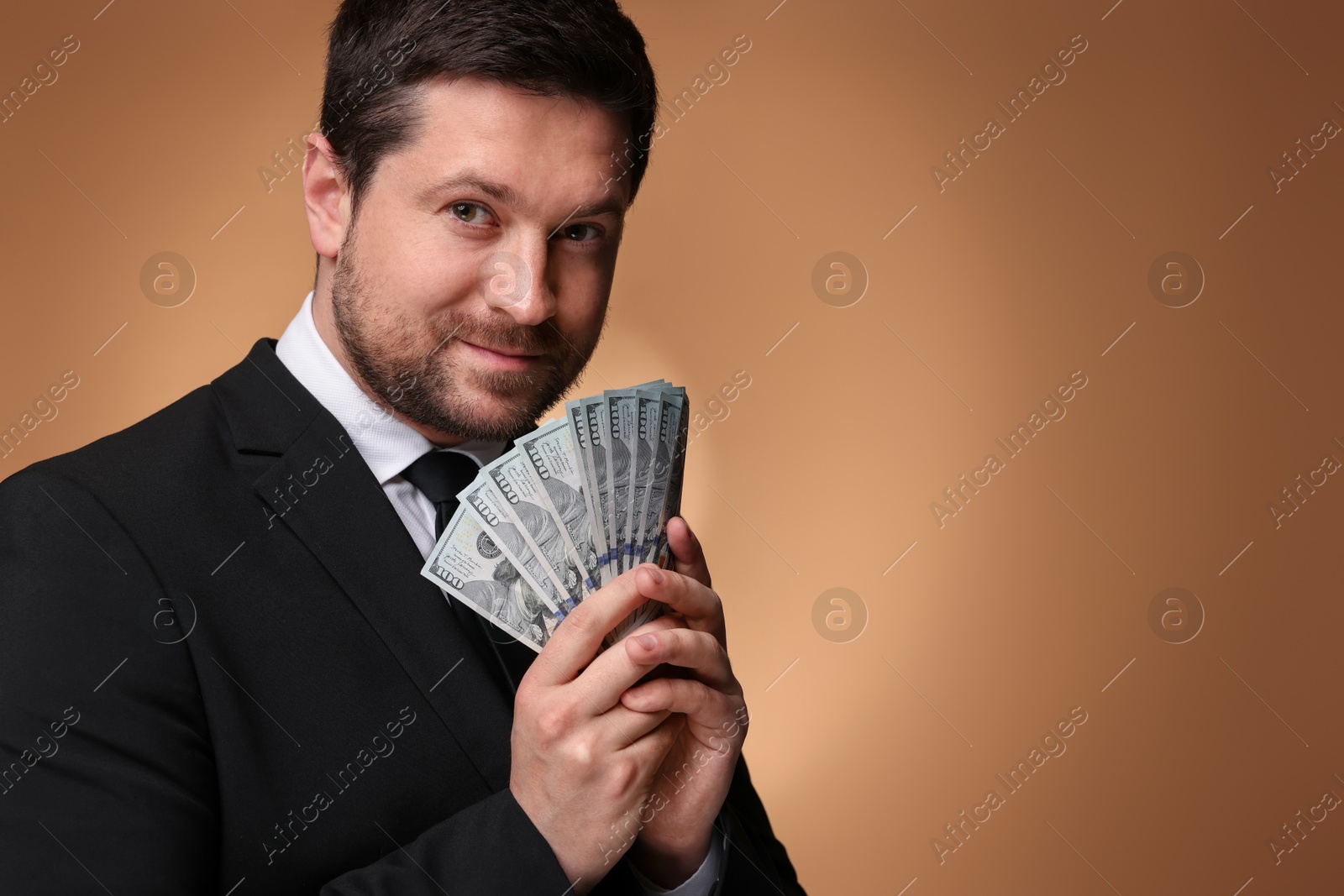 Greedy banker with dollar banknotes on golden background. Space for text Photo of Greedy banker with dollar banknotes on golden background. Space for text