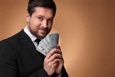 Photo of Greedy banker with dollar banknotes on golden background. Space for text