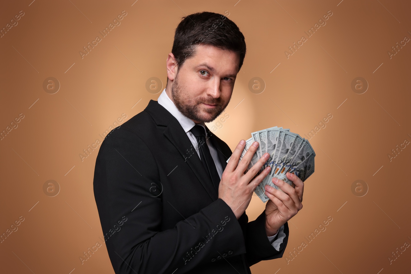 Greedy banker with dollar banknotes on golden background Photo of Greedy banker with dollar banknotes on golden background