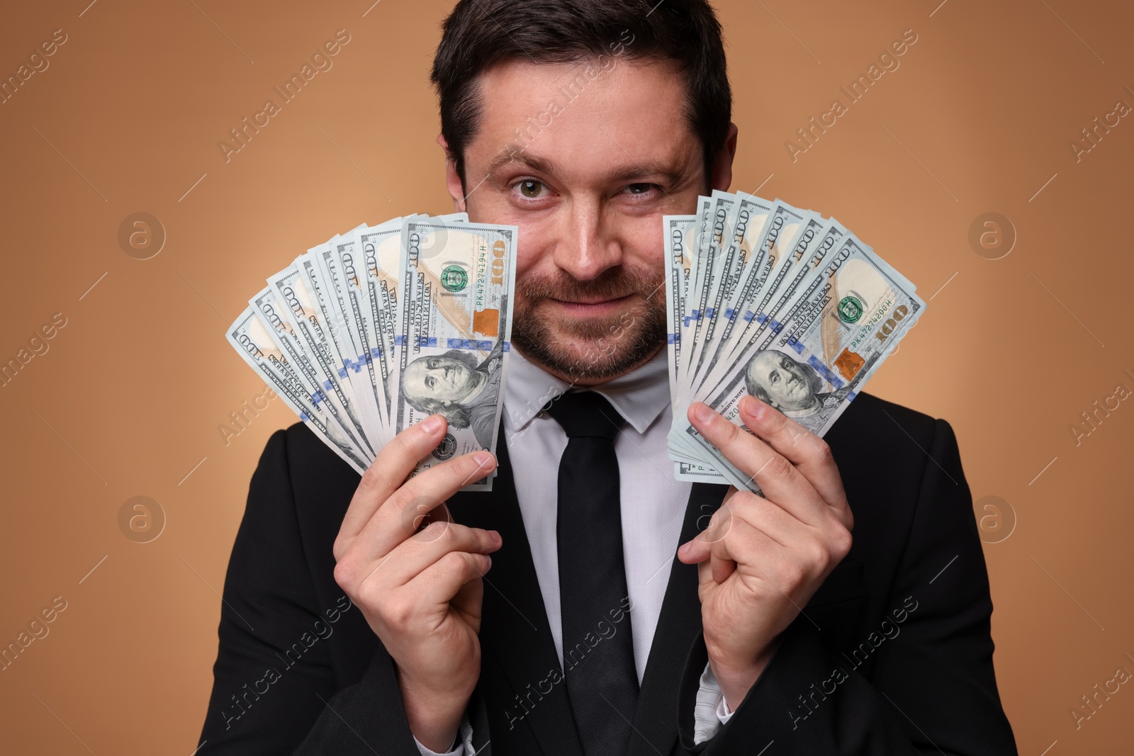 Greedy banker with dollar banknotes on golden background, closeup Photo of Greedy banker with dollar banknotes on golden background, closeup