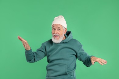 Photo of Elderly man in stylish outfit on green background