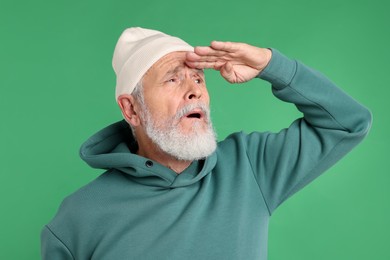 Photo of Elderly man in stylish outfit on green background