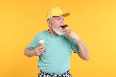 Photo of Elderly man in stylish outfit eating ice cream on orange background