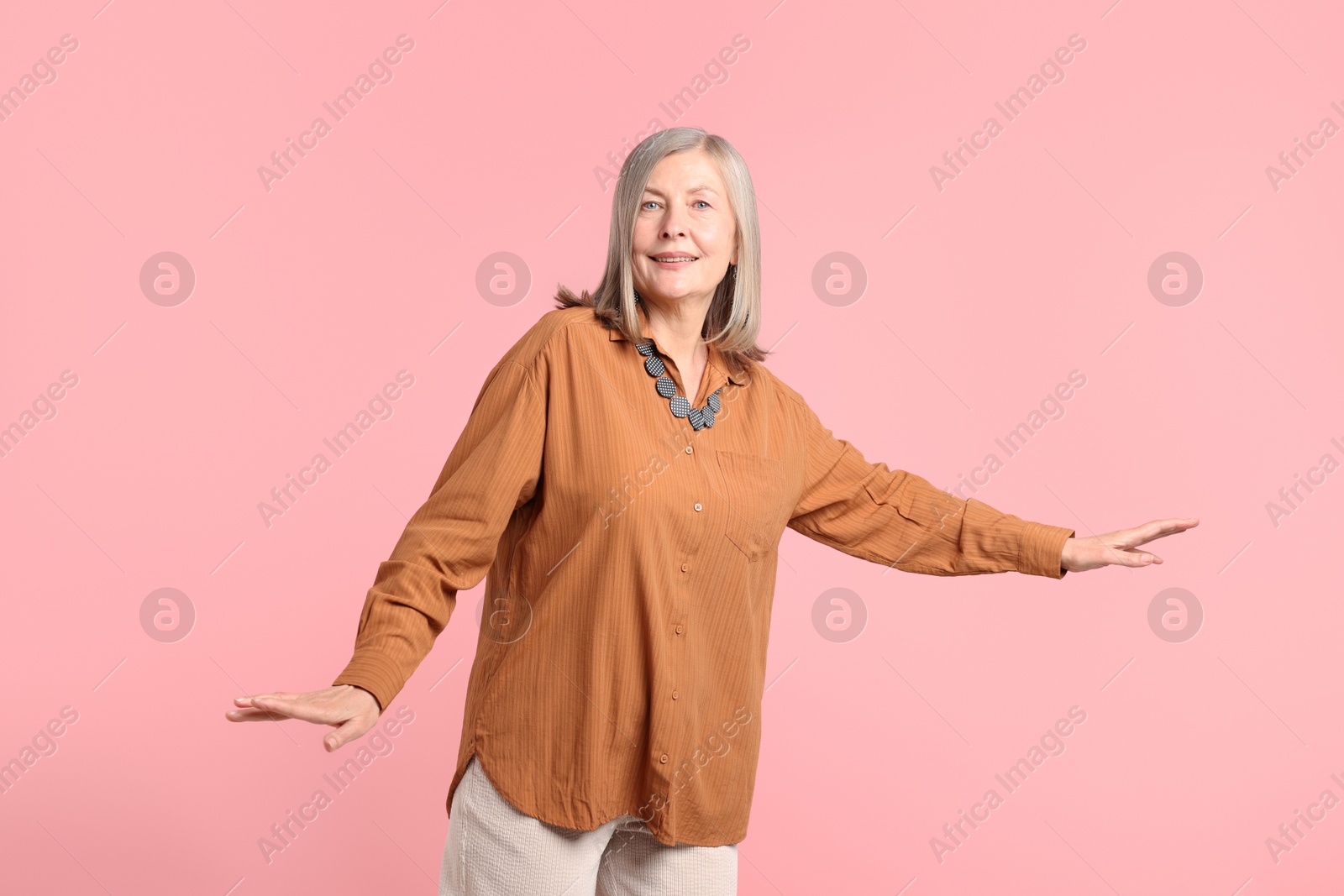Photo of Senior woman in stylish outfit on pink background