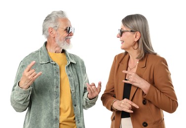 Photo of Senior couple in stylish outfits making rock gestures on white background