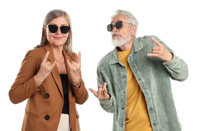 Photo of Senior couple in stylish outfits making rock gestures on white background