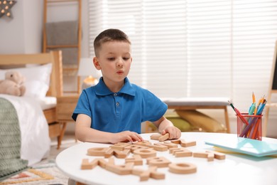 Photo of Dyslexia. Little boy learning letters at table indoors