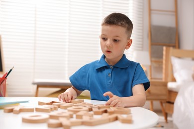 Photo of Dyslexia. Little boy learning letters at table indoors