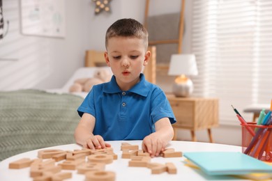 Photo of Dyslexia. Little boy learning letters at table indoors