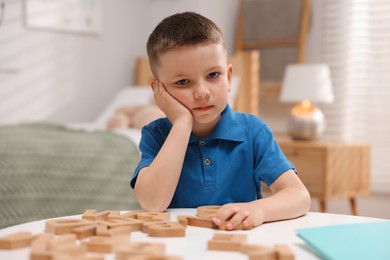 Photo of Dyslexia. Little boy learning letters at table indoors