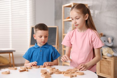 Photo of Dyslexia. Kids learning letters at table indoors