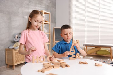 Photo of Dyslexia. Kids learning letters at table indoors