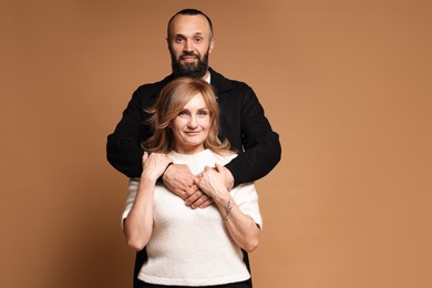 Photo of Portrait of lovely couple on brown background