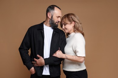 Photo of Portrait of lovely couple on brown background