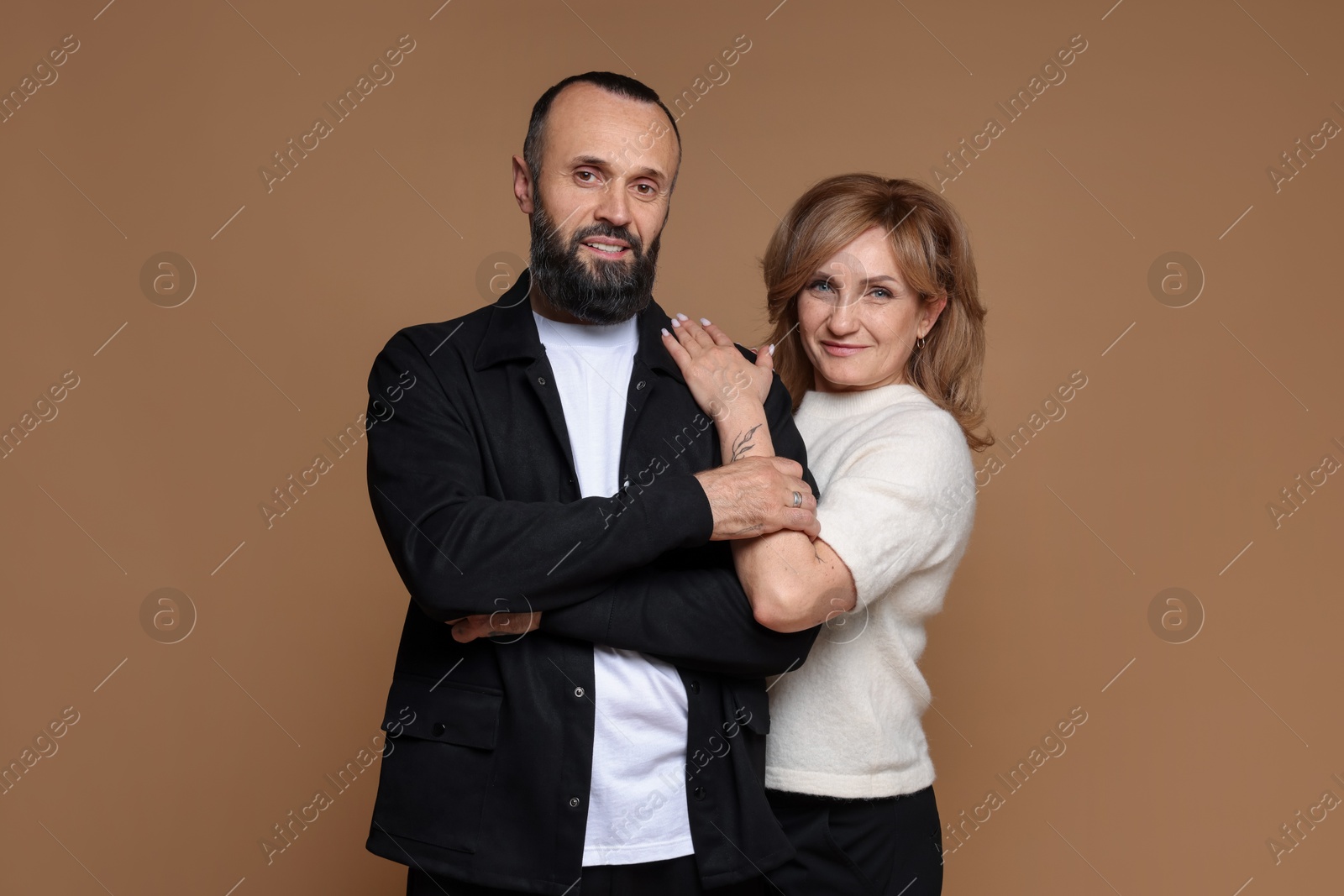 Photo of Portrait of lovely couple on brown background