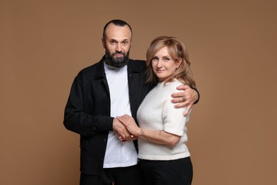 Photo of Portrait of lovely couple on brown background