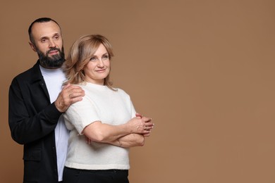 Photo of Portrait of lovely couple on brown background, space for text