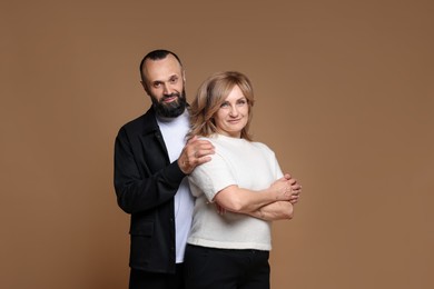 Photo of Portrait of lovely couple on brown background