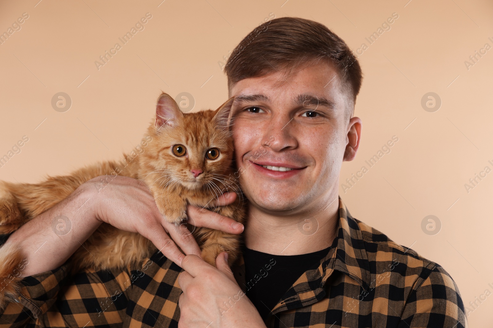 Man with cute ginger cat on beige background Photo of Man with cute ginger cat on beige background