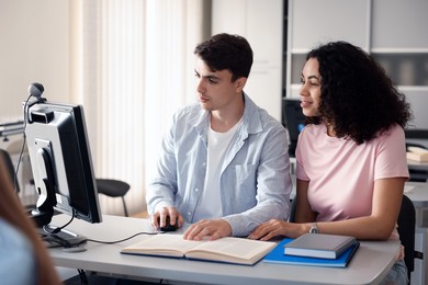 Photo of People studying together at desk in public library