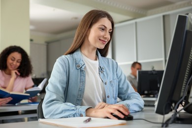 Photo of People working at desks in library, selective focus