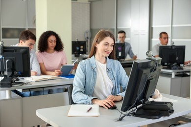 Photo of People working at desks in library, selective focus