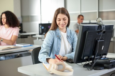 Photo of People working at desks in library, selective focus