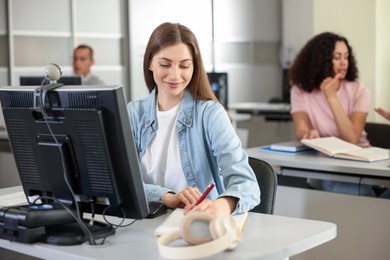 Photo of People working at desks in library, selective focus