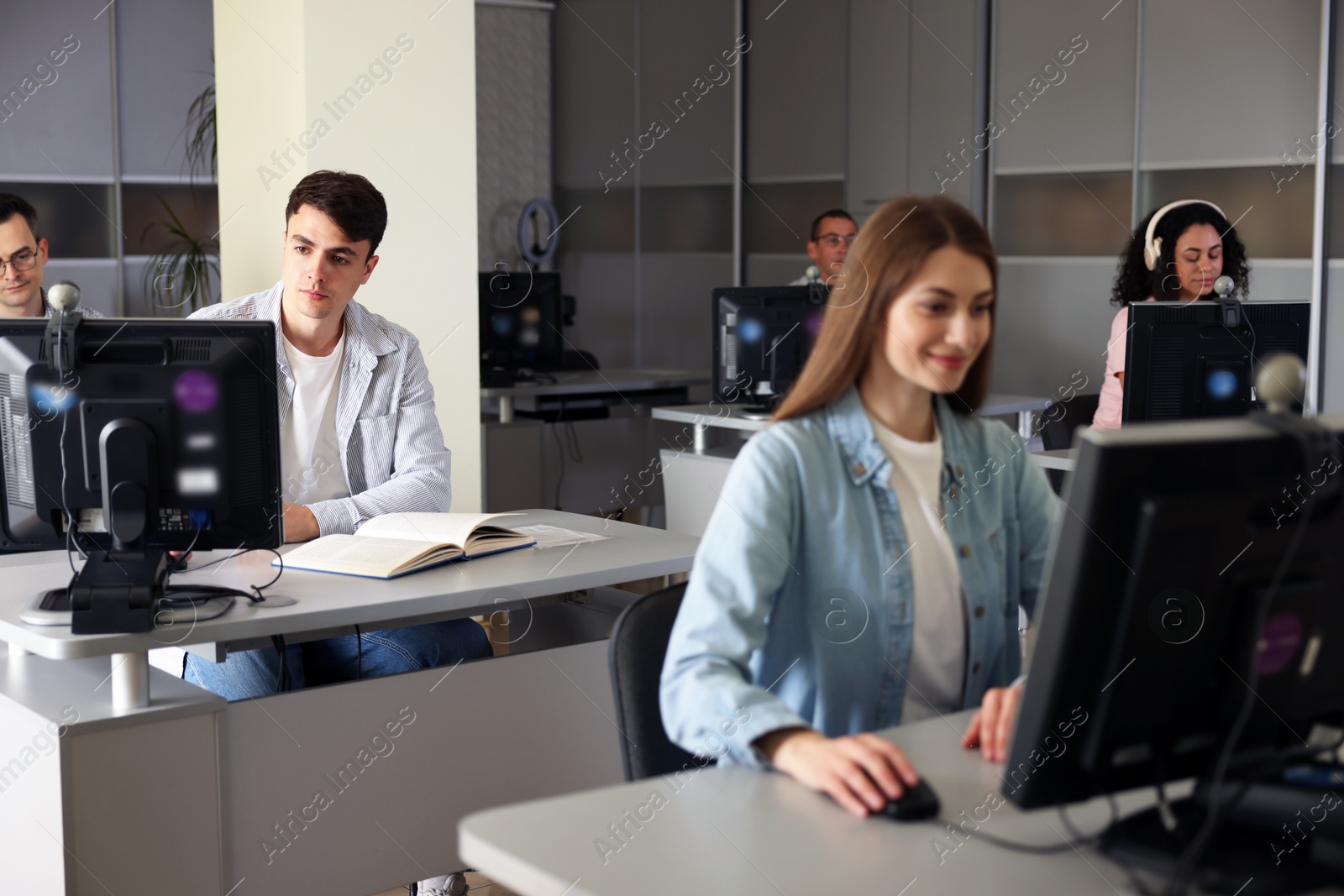 People working at desks in library, selective focus Photo of People working at desks in library, selective focus