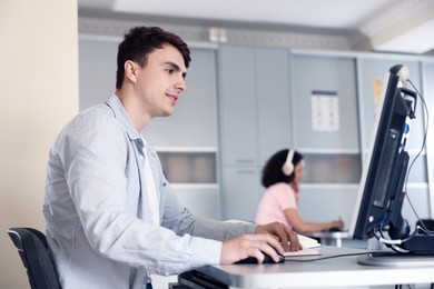 Photo of People working at desks in library, selective focus