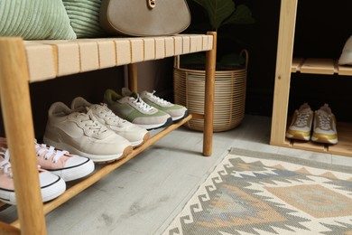 Photo of Different footwear on bench indoors. Shoe storage