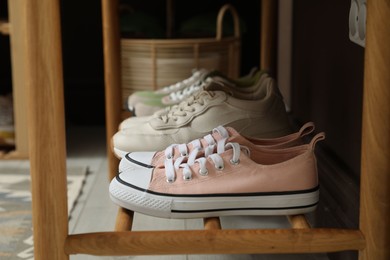 Photo of Different footwear on bench indoors. Shoe storage