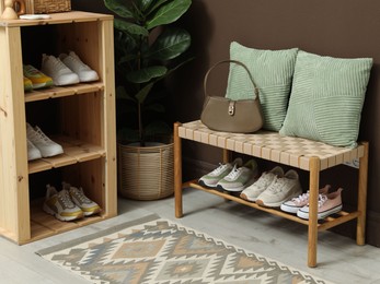Photo of Different footwear on shelves in entryway. Shoe storage