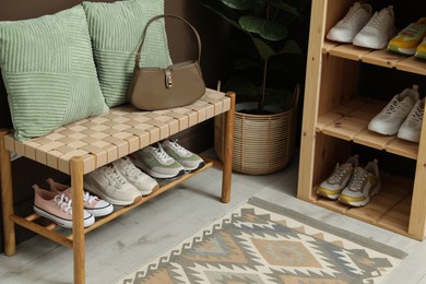 Photo of Different footwear on shelves in entryway. Shoe storage