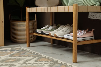 Photo of Different footwear on bench indoors. Shoe storage