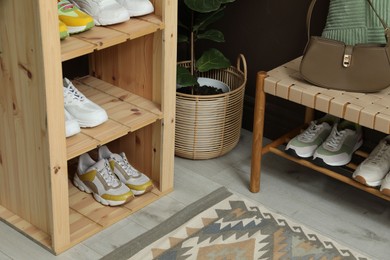 Photo of Different footwear on shelves in entryway. Shoe storage