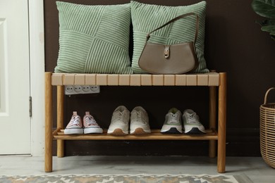 Photo of Different footwear on bench indoors. Shoe storage