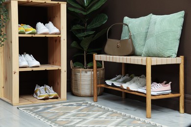Photo of Different footwear on shelves in entryway. Shoe storage