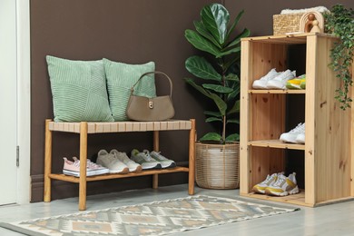 Photo of Different footwear on shelves in entryway. Shoe storage
