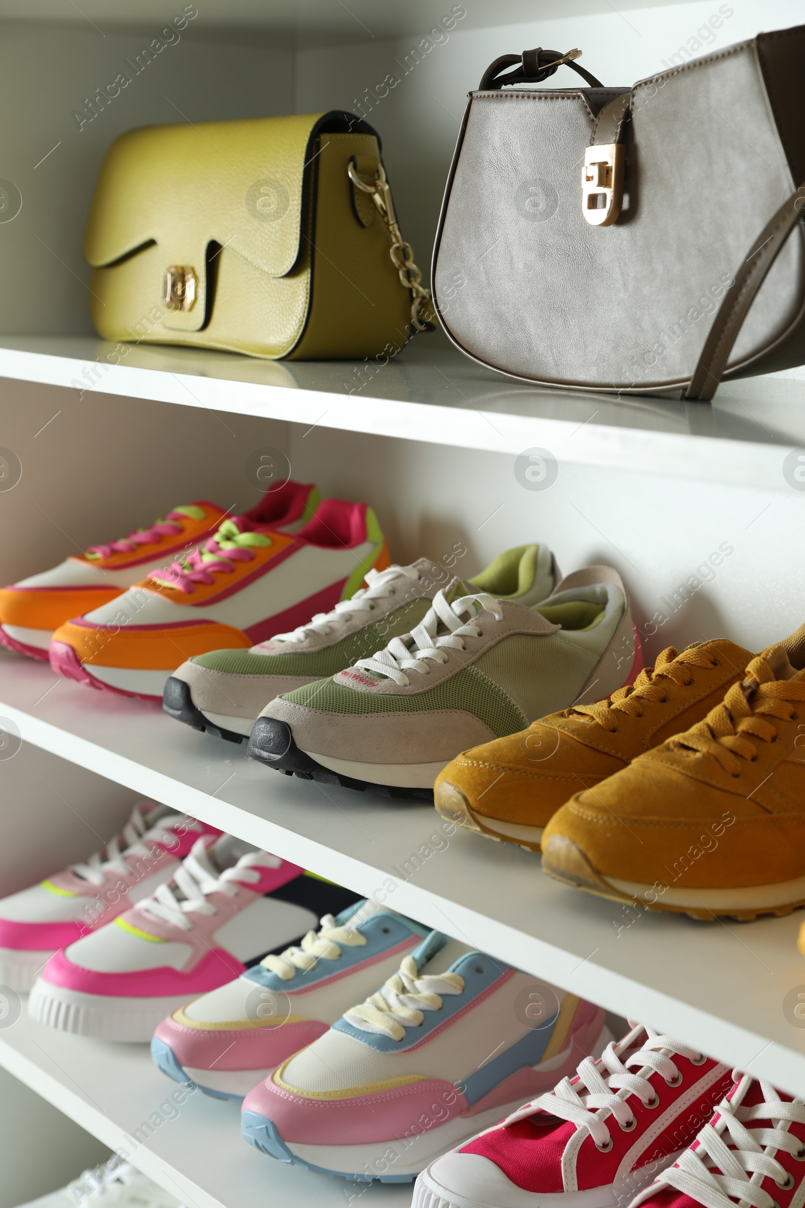 Photo of Different footwear on shelves indoors, closeup. Shoe storage