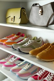 Photo of Different footwear on shelves indoors, closeup. Shoe storage