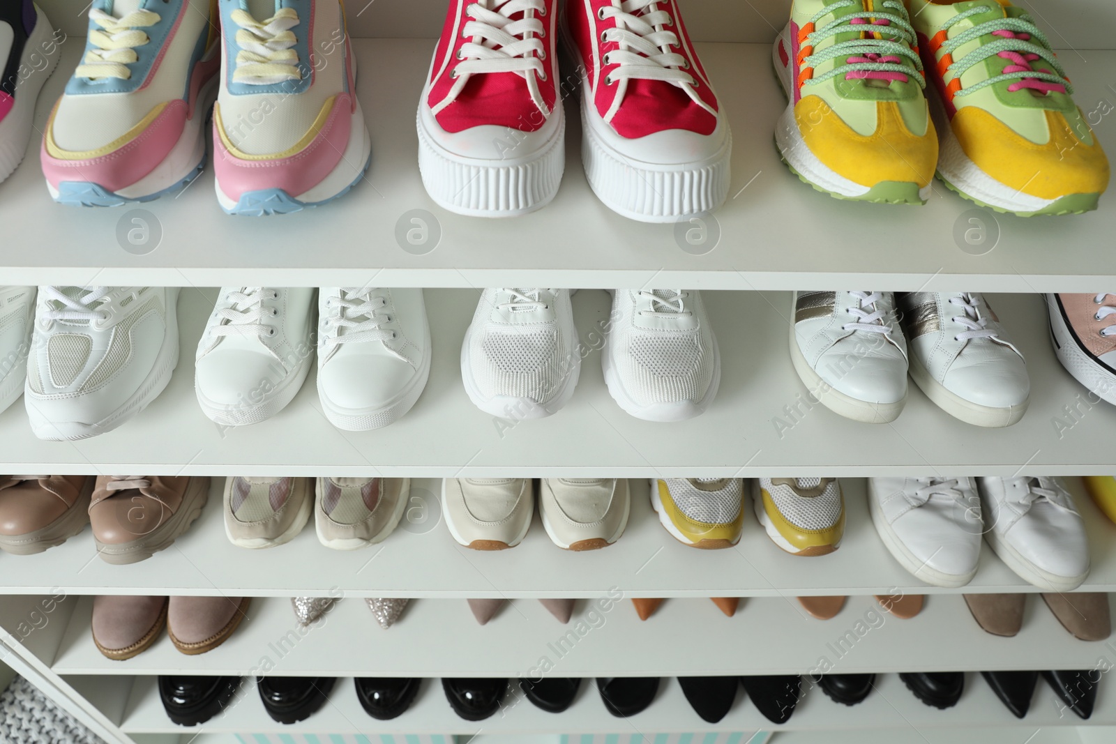Different footwear on shelves indoors, closeup. Shoe storage Photo of Different footwear on shelves indoors, closeup. Shoe storage