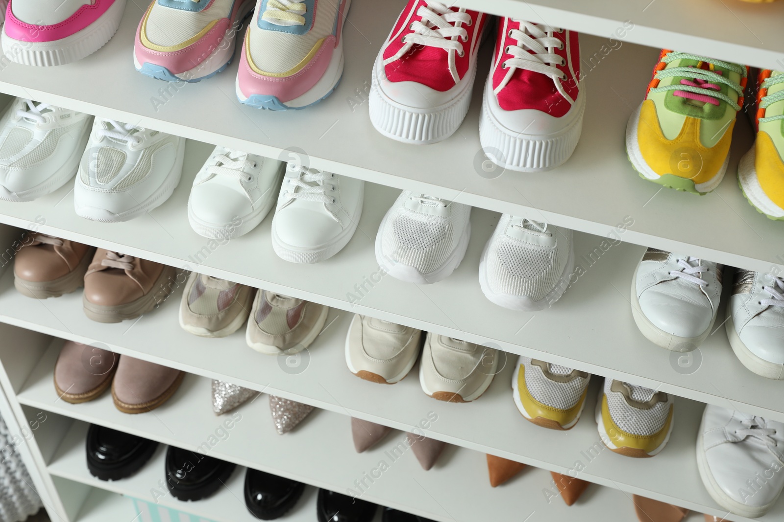 Different footwear on shelves indoors, closeup. Shoe storage Photo of Different footwear on shelves indoors, closeup. Shoe storage