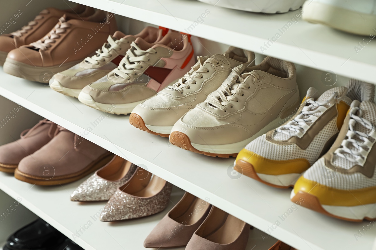 Different footwear on shelves indoors, closeup. Shoe storage Photo of Different footwear on shelves indoors, closeup. Shoe storage