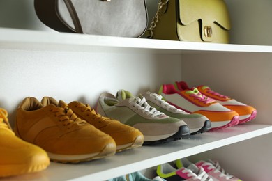 Photo of Different footwear on shelves indoors, closeup. Shoe storage