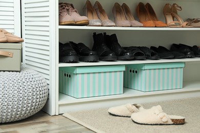Photo of Different footwear on shelves in closet. Shoe storage