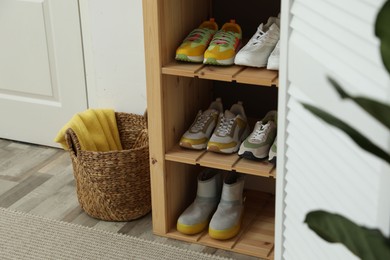 Photo of Different footwear on shelves in entryway. Shoe storage