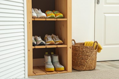Photo of Different footwear on shelves in entryway. Shoe storage