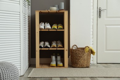 Photo of Different footwear on shelves in entryway. Shoe storage